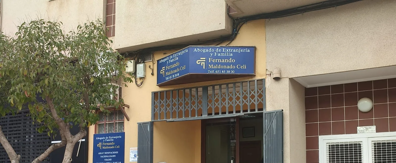 Fachada del despacho en la Avenida de Lorca de Totana, con el rótulo azul que dice Abogado de Extranjería y Familia, Fernando Maldonado Celi.